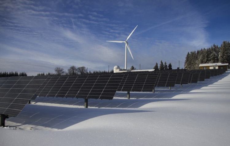 Solar panels and windmill in snow