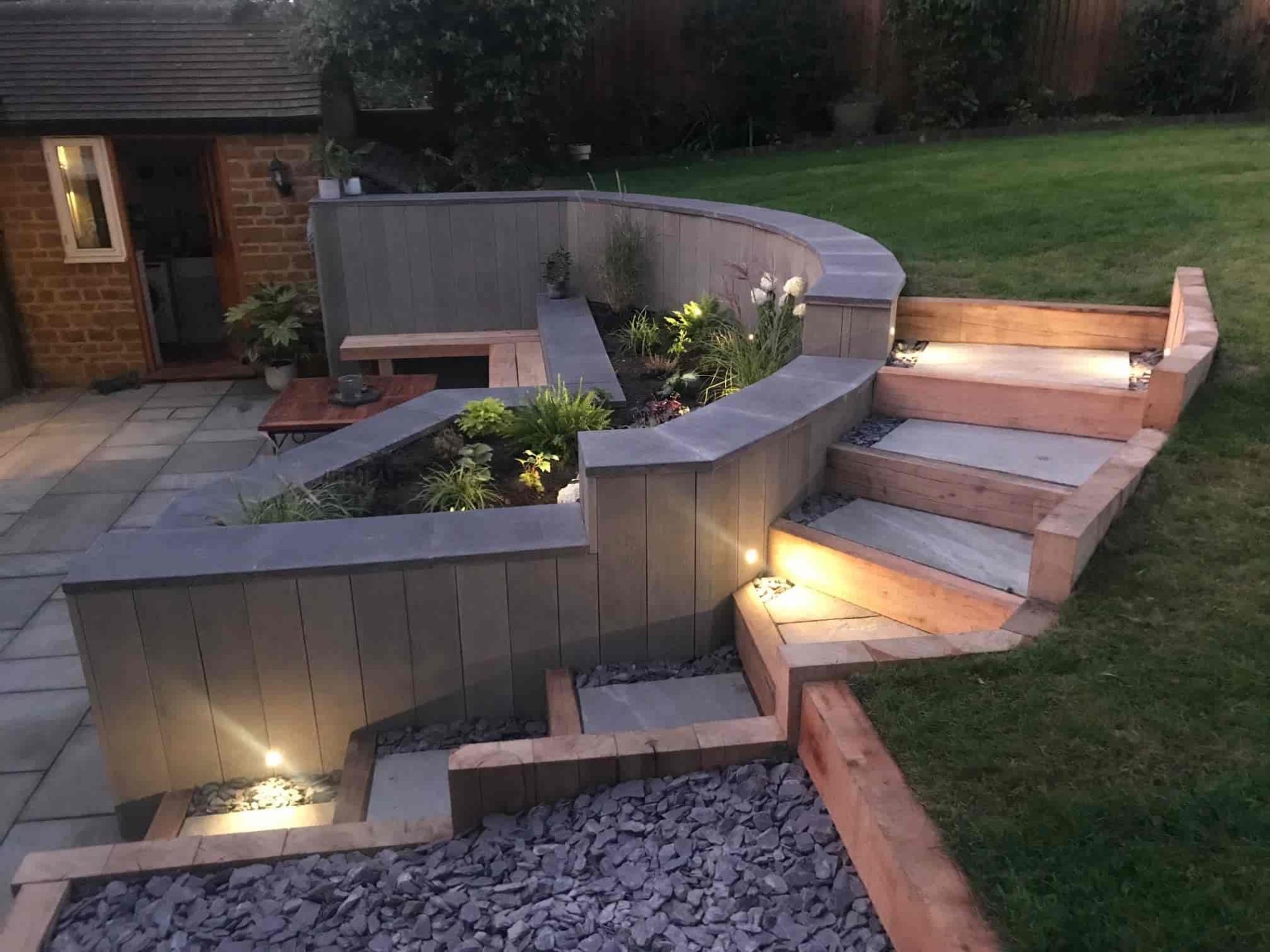 garden in the evening with lights on path and seating
